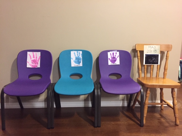 4 chairs, the kids hand prints on papers with their name and birth years. And the baby's ultrasound picture.