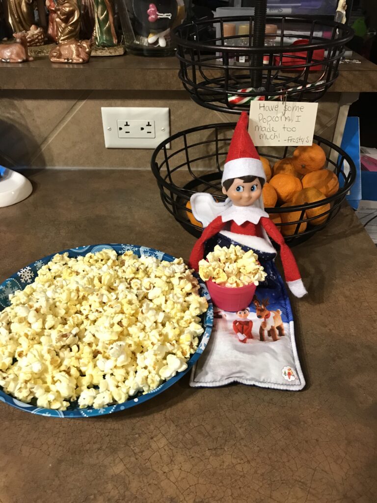 Frosty Spark our elf with a bowl of popcorn.