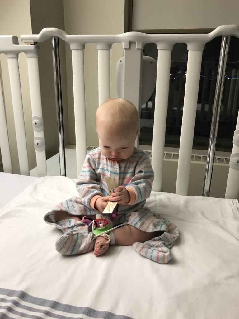 Kennedy playing in the hospital crib.